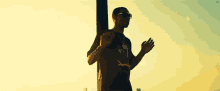 a man standing next to a pole with his hands up
