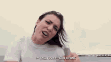 a woman is standing on the beach holding a bottle of water and yelling .