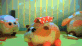 a stuffed animal with a red polka dot hat is standing next to another stuffed animal