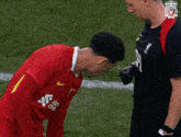 a soccer player wearing a red shirt that says standard chartered on it