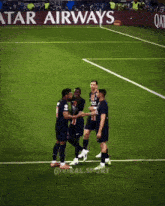 soccer players shaking hands on a field with an advertisement for qatar airways in the background
