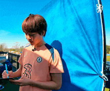 a young man wearing a shirt that says ' chelsea ' on it