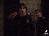 three men are standing in front of a car and one of them says i love you the most