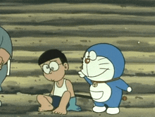 a cartoon character named doraemon is standing next to a boy sitting on the ground
