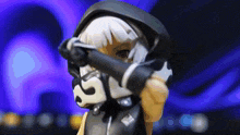 a figurine of a girl with white hair and a black hood covering her face