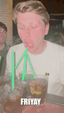 a man drinking through a green straw with the word fri yay written above him