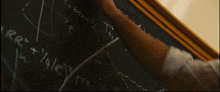 a person is writing on a blackboard that says ' eee + ' on it