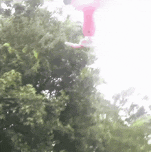 a person in pink pants is hanging from a rope in the air