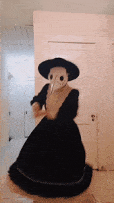 a person wearing a plague doctor costume is dancing in a room .