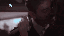 a man and woman are kissing with a blue a in the background