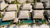 an aerial view of a tropical resort with thatched roofs