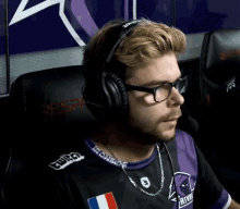 a man wearing headphones and a shirt with ironside on the collar