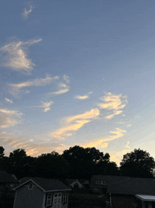 a sunset over a residential area with a house in the foreground