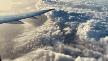 the wing of an airplane is visible in the clouds
