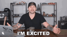 a man is sitting at a desk with his arms outstretched and the words i 'm excited above him
