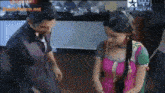 a man and a woman are standing next to each other on a television screen with a star written on it