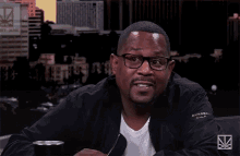 a man with glasses and a black jacket says yeah