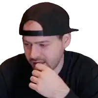 a man wearing a black hat and a black shirt has his hand on his mouth
