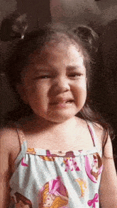 a little girl is crying while wearing a princess dress