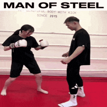 a man and a woman are boxing in a ring with the words man of steel written above them