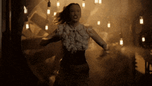 a woman in a ruffled blouse is dancing in a dark room