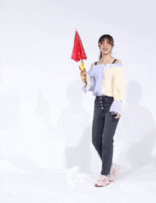a woman in a ponytail is holding a red umbrella in her hand