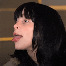 a close up of a woman 's face with her tongue hanging out