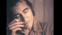 a man is smoking a cigarette and looking down