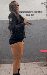 a woman wearing a black hoodie with a w logo on the sleeve