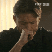 a man with a beard is covering his nose with his hand and the word countdown is behind him