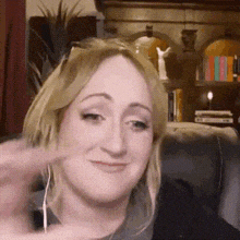 a woman is sitting on a couch wearing ear buds and making a funny face .