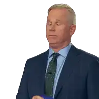 a man in a suit and tie holds a piece of paper in his hand