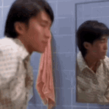a man is looking at his reflection in a mirror