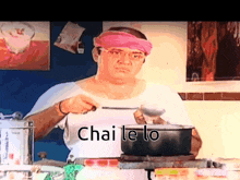 a man wearing a pink headband is cooking in a kitchen and the words chai le lo are on the screen