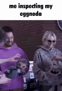 a group of people are standing next to each other and one of them is holding a stuffed animal with a face on it .
