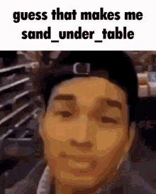 a man wearing a hat with the words guess that makes me sand under table on the top