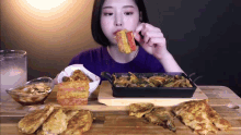 a woman is sitting at a table eating a sandwich