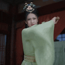 a woman in a green dress with a crown on her head
