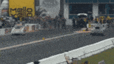 two racing cars are on a track with a nhra sign behind them