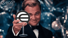 a man in a tuxedo is holding a wine glass with a euro sign in front of his eye