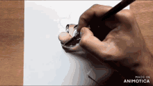 a hand draws a cartoon character on a piece of paper