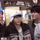 a man wearing a hat and a sweater says yas y niko in a foreign language
