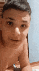 a shirtless young man is making a funny face in a bedroom .