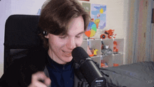 a man wearing headphones and a shure microphone is smiling