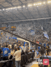 a crowd of people in a stadium with a gif maker icon