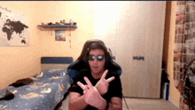 a man wearing sunglasses and headphones is making a peace sign while sitting in a gaming chair .