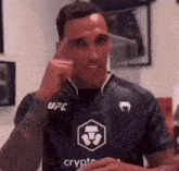 a man wearing a black ufc shirt is thinking .