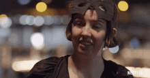 a woman wearing a mask with a netflix logo on the bottom right