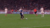 soccer players on a field with an ad for qatar airwa