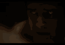 a man without a shirt is standing in a dark room .